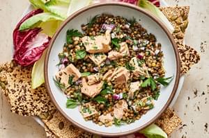 tuna lentil salad in a bowl made with lentils, tuna, mayo, dijon, lemon zest & juice, spices, fresh herbs, red onion & capers