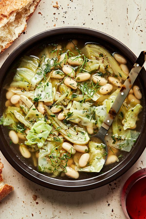 a bowl White Bean Soup with Dill and Cabbage with crusty bread alongside