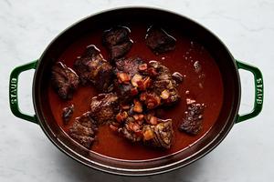 browned chuck roast added back into the sauce in a dutch oven for beef bourguignon