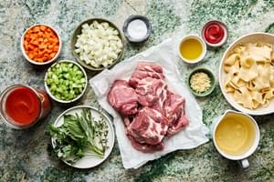 pork, onion, carrots, celery, tomato sauce, wine, thyme, basil, parsley and sage in prep bowls to make pork ragu