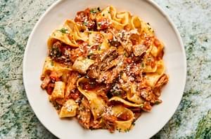 homemade braised pork ragu served over cooked pappardelle noodles