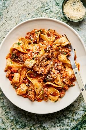 homemade braised pork ragu served over cooked pappardelle noodles