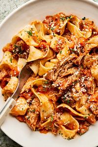 homemade braised pork ragu served over cooked pappardelle noodles