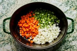 onion, carrots and celery cooking in pork fat in a pot