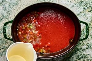 ragu sauce in a pot made with onion, carrots, celery, tomato sauce, white wine, basil, thyme sage and parsley