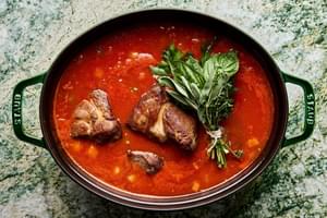 browned pork cooking in onion, carrots, celery, tomato sauce, white wine, basil, thyme sage and parsley