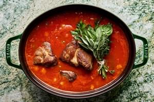 browned pork cooking in onion, carrots, celery, tomato sauce, white wine, basil, thyme sage and parsley
