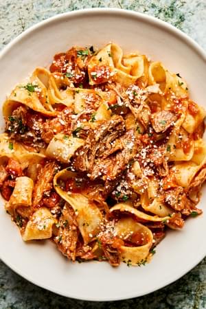 homemade braised pork ragu served over cooked pappardelle noodles