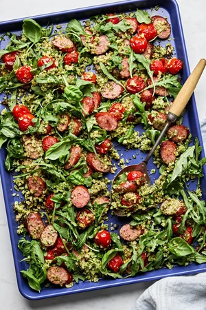 Cauliflower Rice Sheet Pan made with smoked sausage, pesto, cherry tomatoes, arugula, basil, salt & pepper