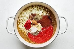 ground beef, stock, onion, garlic, tomatoes, Worcestershire and spices being added together in a soup pot