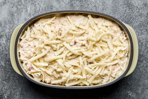 a baking dish of crab dip made with cream cheese, mayo, sour cream, spices and cheese ready for the oven