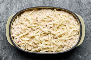 a baking dish of crab dip made with cream cheese, mayo, sour cream, spices and cheese ready for the oven