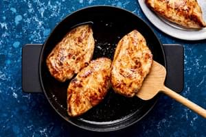 3 cooked chicken breasts seasoned with salt, garlic powder and brown sugar being browned in vegetable oil in a skillet