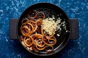garlic and onions being cooked in a skillet