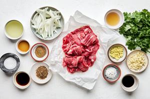 flank steak, onion, garlic, soy sauce, corn starch, ginger, sichuan peppercorns, cumin, sesame oil and cilantro in prep bowls