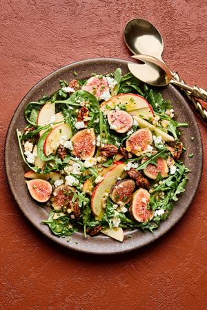 A fig and goat cheese salad made with spinach, arugula, candied pecans, a citrusy dijon vinaigrette, topped with chives