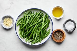 green beans, olive oil, salt, pepper and garlic in prep bowls to make garlic green beans