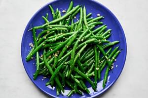garlic green beans on a blue plate