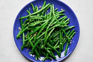 garlic green beans on a blue plate