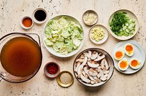 bone broth, mushrooms, cabbage, soy sauce, chili paste, garlic, ginger, green onions, sesame seeds and boiled eggs in bowls