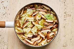 a pot of gingery vegetable soup with bone broth, cabbage, mushrooms, soy sauce, chili paste, garlic and ginger