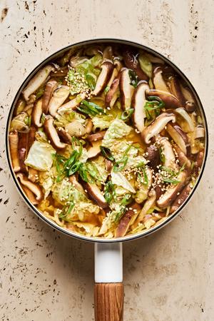 a pot of gingery vegetable soup with bone broth, cabbage, mushrooms, soy sauce, chili paste, garlic and ginger