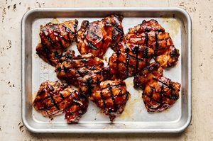 sweet and smoky grilled huli huli chicken resting on a baking sheet, the perfect hawaiian summer meal