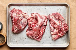 lamb shoulder cut into 6 inch pieces being seasoned with salt and pepper