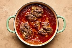 lamb curry cooking in a pot seasoned with garlic, garam masala, cumin, turmeric and cinnamon