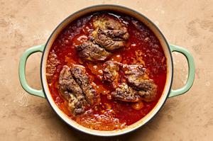 lamb curry cooking in a pot seasoned with garlic, garam masala, cumin, turmeric and cinnamon
