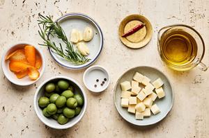 green olives, Gruyère, garlic, orange peel, rosemary, peppercorn, dried chili and olive oil in prep bowls