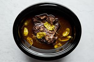 Mississippi pot roast in a slow cooker made with au jus seasoning, a ranch packet, butter, pepperoncini & pepperoncini juice