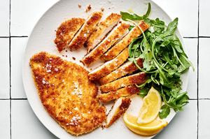 panko chicken sliced on a plate served with lemon wedges