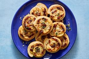 plate of puff pastry pinwheels filled with cream cheese, swiss, caramelized onions, dijon & thyme