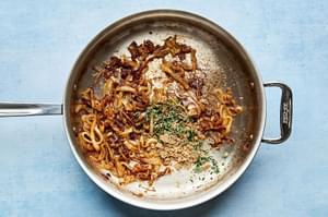 caramelized onions being cooked in a skillet