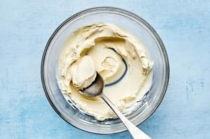 cream cheese and dijon mustard being stirred together in a bowl