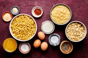creamed corn, ritz crackers, butter, cream, eggs, sugar and spices in prep bowls to make scalloped corn casserole