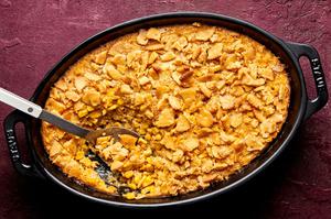 a dish of scalloped corn casserole made with creamed corn, cream, eggs, sugar and spices topped with crushed ritz crackers