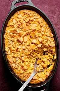 a dish of scalloped corn casserole topped with crushed ritz crackers