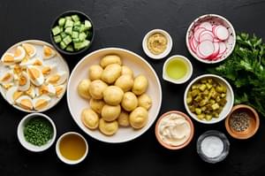 gold potatoes, eggs, radishes, pickles, parsley, chives, cucumber, spices, mayo and stone ground mustard in prep bowls