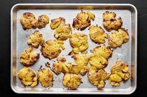 roasted smashed potatoes with olive oil and salt on a baking sheet