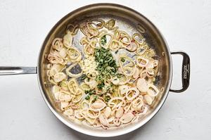 garlic, sage, and thyme being added to shallots and butter in a skillet