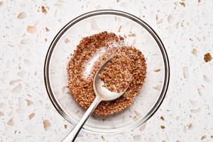 brown sugar, garlic, chipotle chili powder, salt, & pepper being stirred together in a bowl