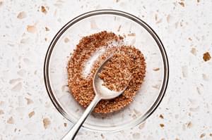 brown sugar, garlic, chipotle chili powder, salt, & pepper being stirred together in a bowl