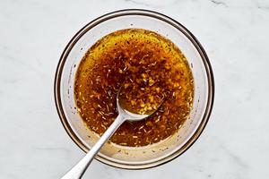 olive oil, garlic, Italian seasoning, salt, paprika and pepper being stirred together in a bowl