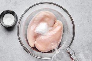 chicken breast soaking in a salt brine to make super juicy air fryer chicken breast, a quick and protein recipe