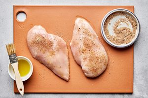 chicken breast being rubbed with olive oil and a spice mix to make in the air fryer, a easy, healthy protein