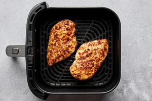 juicy, golden Air fryer chicken breasts perfectly seasoned inside an air fryer, a healthy quick protein option