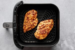 juicy, golden Air fryer chicken breasts perfectly seasoned inside an air fryer, a healthy quick protein option
