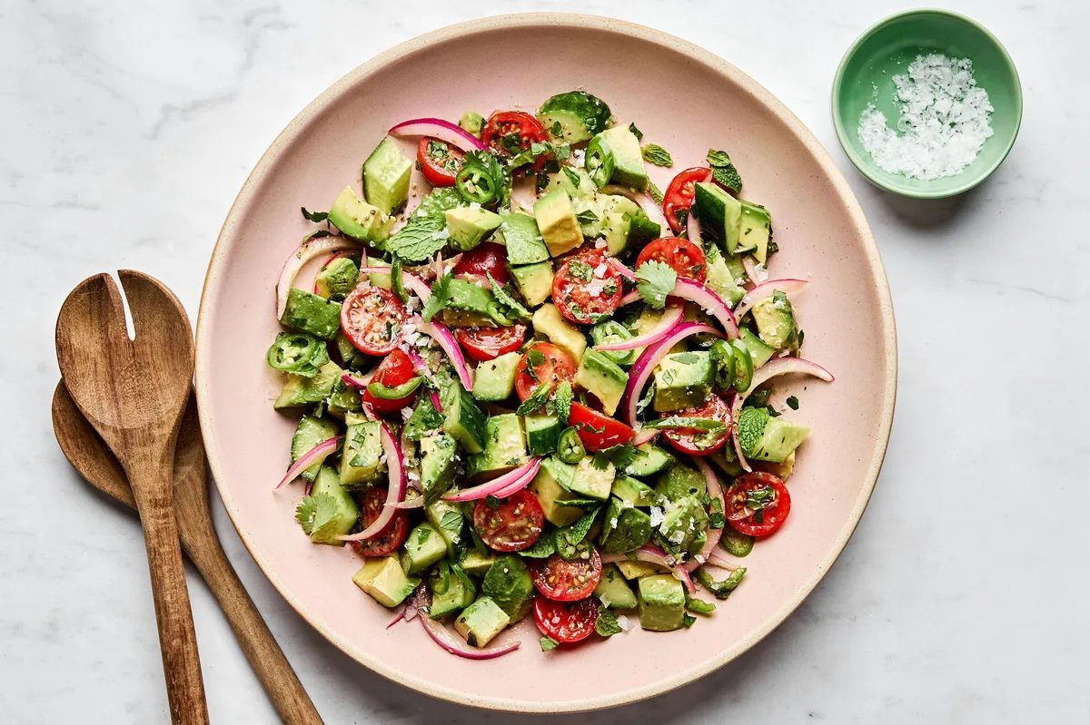 avocado salad made with tomatoes, cucumbers, serrano pepper, herbs and homemade vinaigrette topped with flaky salt